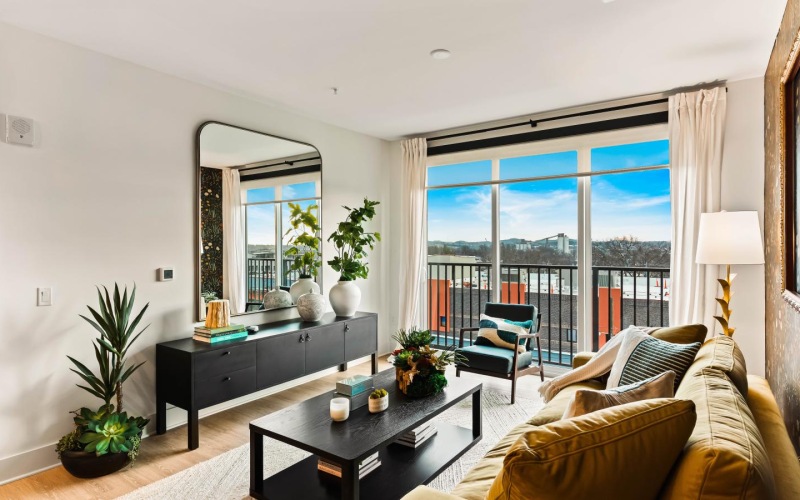 a living room with a large window, a couch and a coffee table