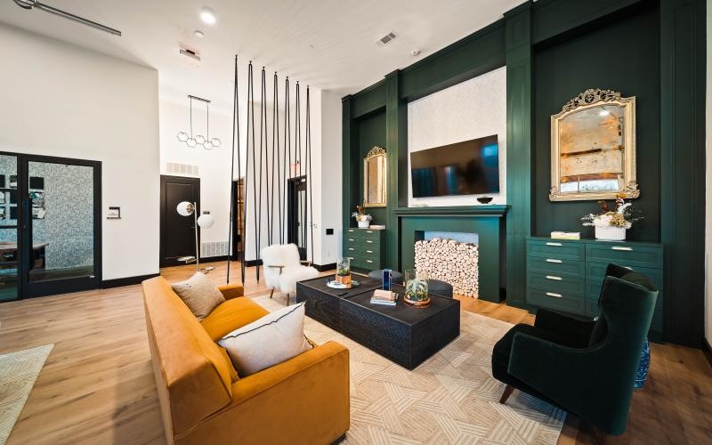 a clubhouse room with a couch, chairs and table and a tv
